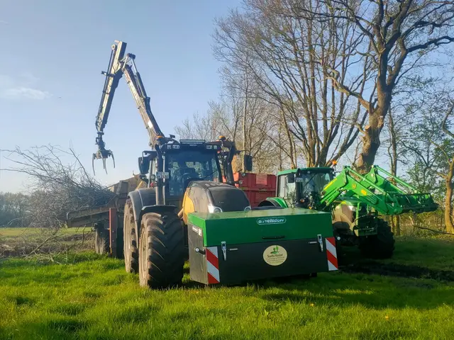 Zwei Traktoren mit Ladekran bei der Landschaftspflege am Gehölzrand