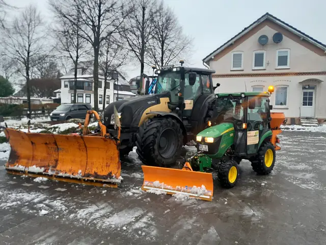 Zwei Traktoren mit Schneeschildern im Winterdienst